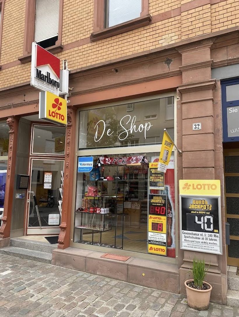 Ladenfront des De Shop in der Marktstraße 32 in Landau mit Schaufenster, Lotto- und Hermes-Schild
